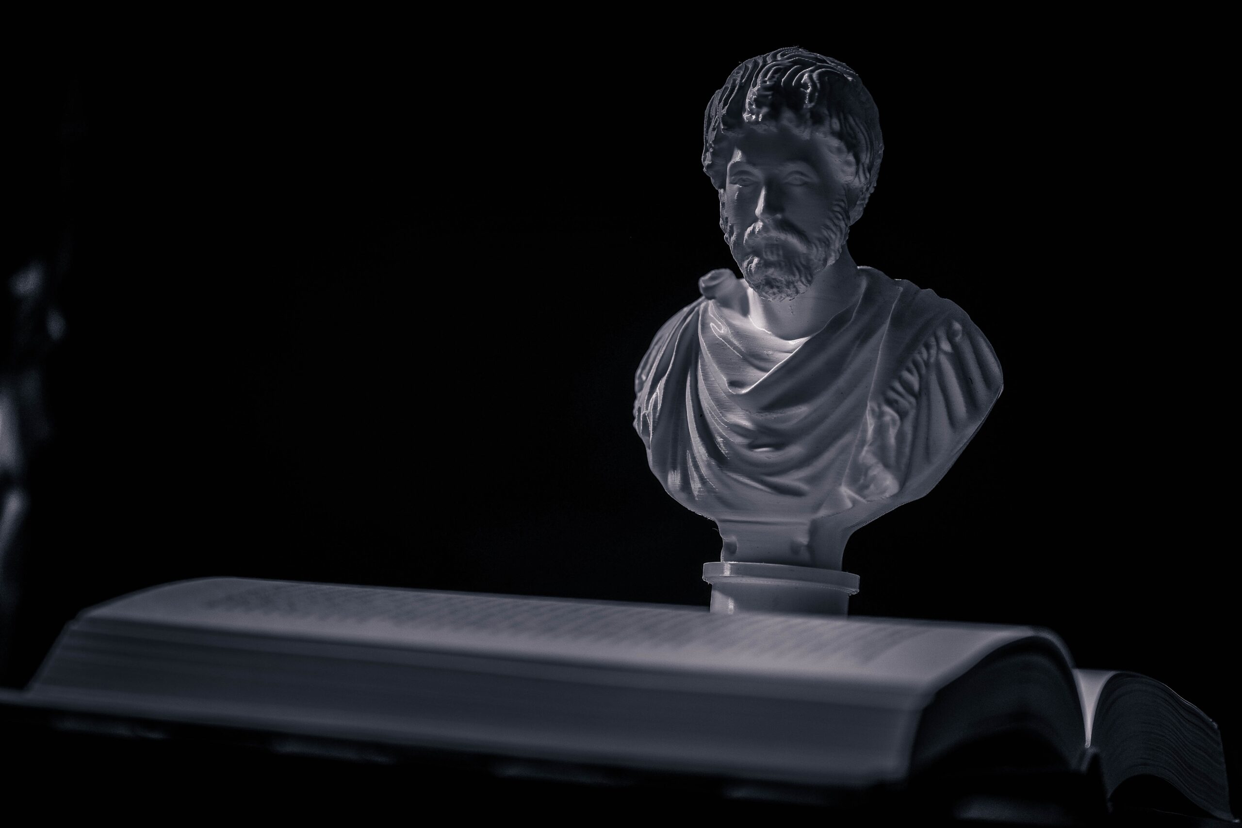 Bust of Stoic philosopher Marcus Aurelius with an open book, symbolizing Stoic philosophy and wisdom.